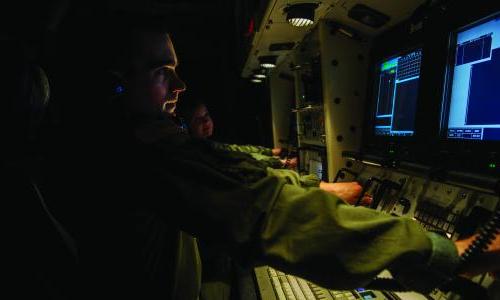 An instructor sits at missile launch controls during a simulation training